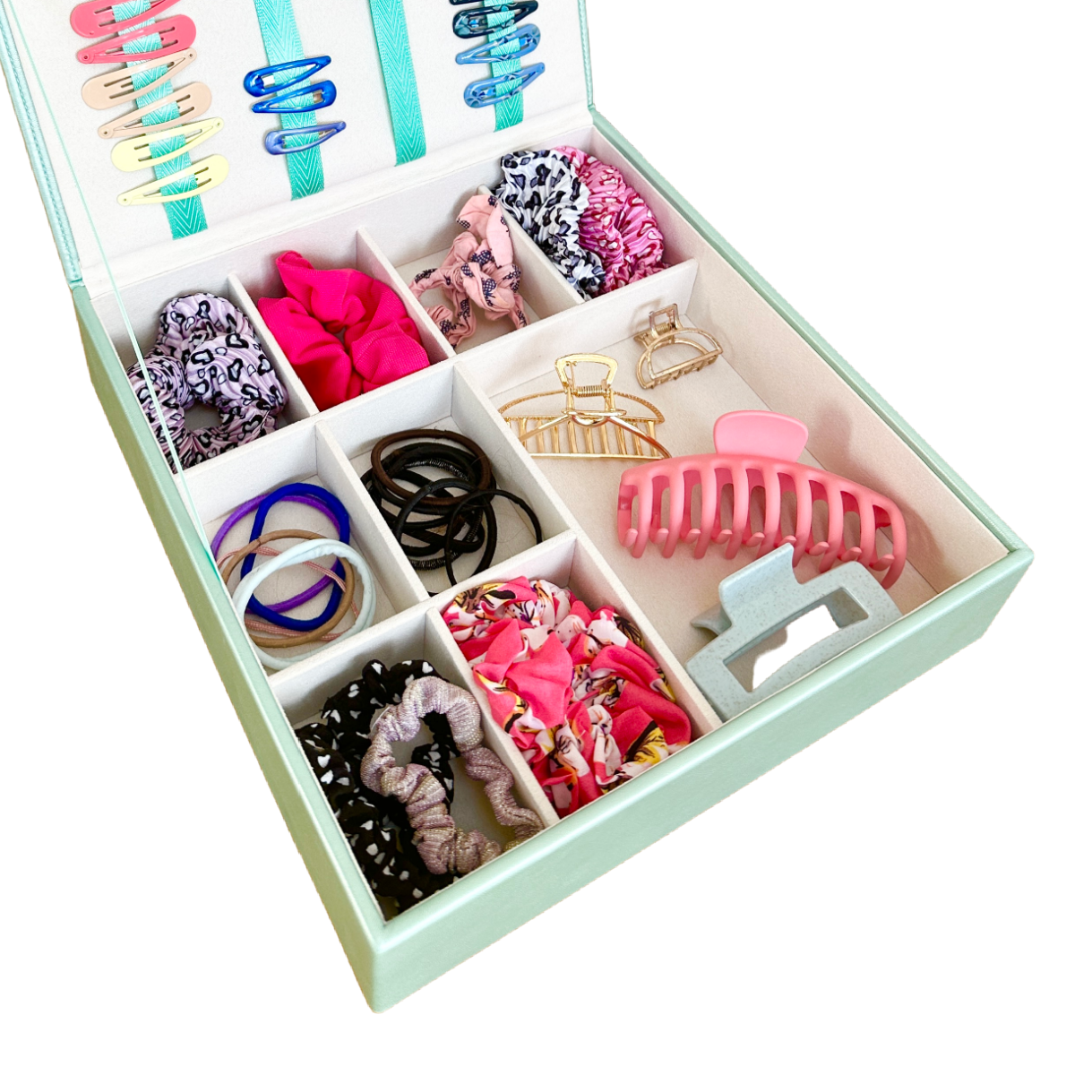 The image shows the internal of bottom section of the mint green hair accessory organiser. The grid inside has one large compartment for hair bands and larger accessories, and there are 8 smaller sections to hold hair bobbles and scrunchies