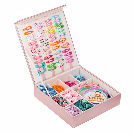 The pink hair accessory organiser is shown at an angle. The storage box is open and shows a beautiful display of girl’s hair accessories. The backdrop is white